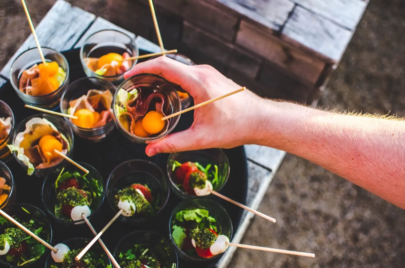 Griechische Canapés im Glas, serviert auf einem Holztisch
